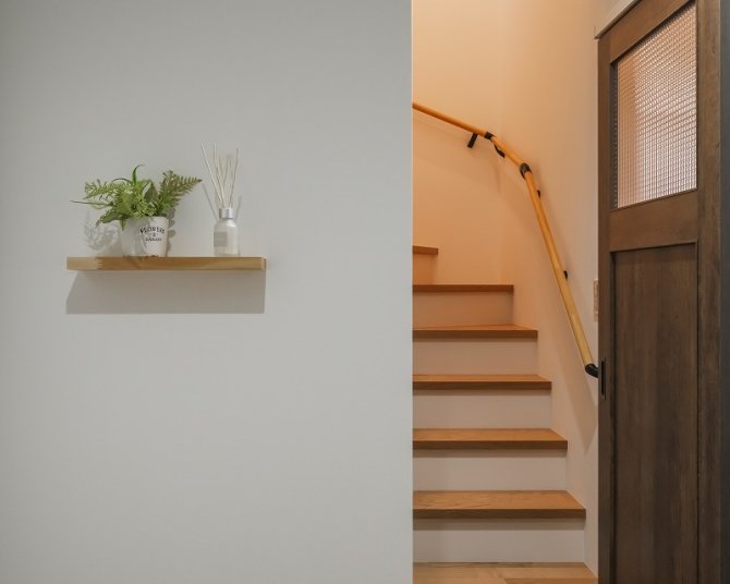 木目フローリングとダーク色の建具が落ち着いた第一印象の玄関。正面の飾り棚には家族の写真や小物などを飾れます。