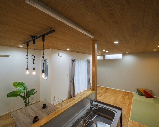 木目天井とフローリングを統一したLDK。ダイニングから和室まで視線が抜け、家族の気配を感じながら過ごせるのびやかな空間です。