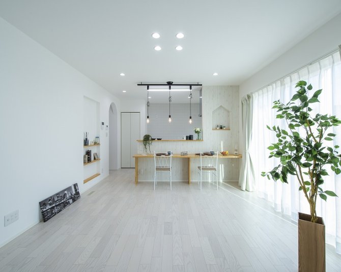 大きな窓からたっぷりと光を取り込む、のびやかなLDK。白を基調にまとめた内装が、空間全体をより広く明るく感じさせます。キッチンと一体で使えるカウンターは、家族の会話が自然と生まれる場所に。造作ニッチとR垂れ壁のデザインが、シンプルな空間にほどよいアクセントを添えています。