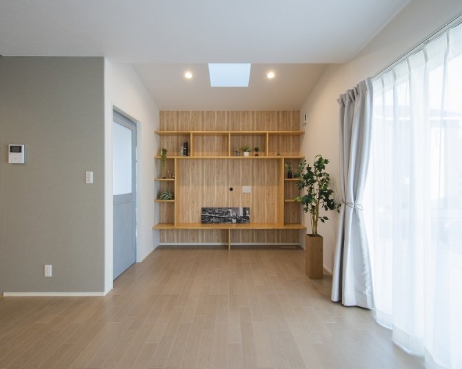 天井の吹き抜けと窓からの自然光が心地よく差し込む、明るく開放的なリビング。
造作の壁面収納は、見せる収納としてインテリア性も高く、お部屋をすっきりと美しく保てます。
木の温もりが感じられるデザインで、暮らしにやさしく馴染む空間です。