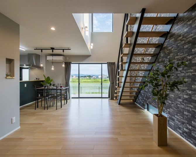 吹き抜けと大開口の窓が、開放感と明るさをもたらすリビング。
鉄骨階段とレンガ調の壁が、スタイリッシュで印象的なアクセントに。
