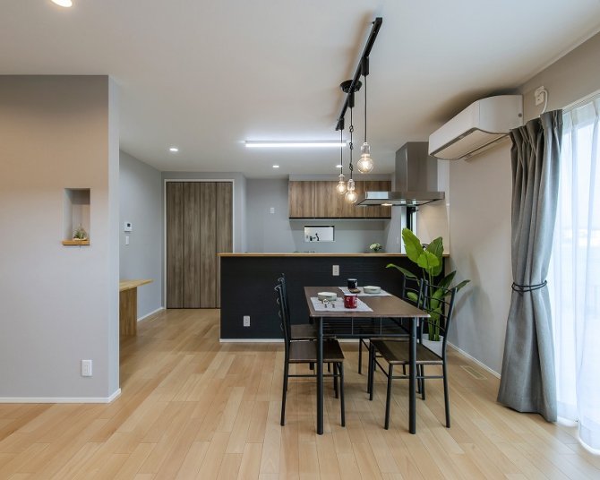 木目とグレーを基調にした、落ち着きのあるダイニングキッチン。
カフェのような雰囲気を演出するペンダントライトや壁面のニッチが空間をオシャレにします。
家族の会話が弾む、心地よい食卓を叶えるデザインです。