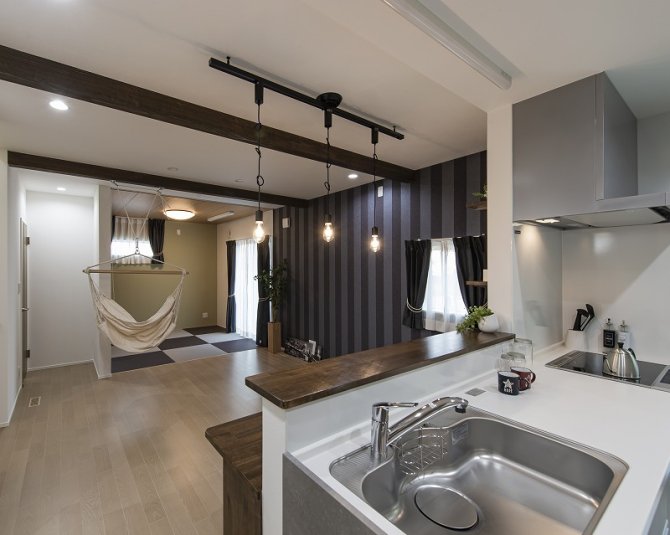 カフェのような空間に遊び心をプラスしたLDK。
ダークカラーのストライプ壁紙と梁あらわし、裸電球の照明が絶妙なバランスで、落ち着きとおしゃれを両立。ハンモックは大人も子どもも楽しめます♪