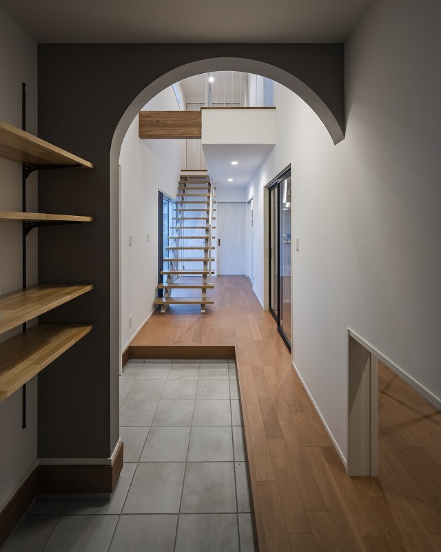アーチ壁が印象的な玄関ホール。
奥へと視線が抜けるスケルトン階段が、開放感とデザイン性を高めます。