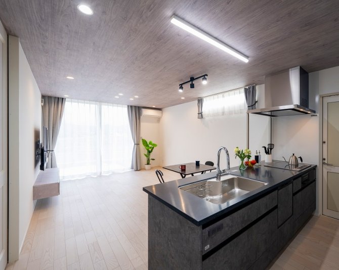 落ち着いたグレーの天井と一体感のあるキッチンが特徴のLDK。
大きな窓からたっぷりと自然光が入り、室内全体が明るく感じられます。
キッチンからリビングまで視線が抜け、家族の様子を見守りながら家事ができます。