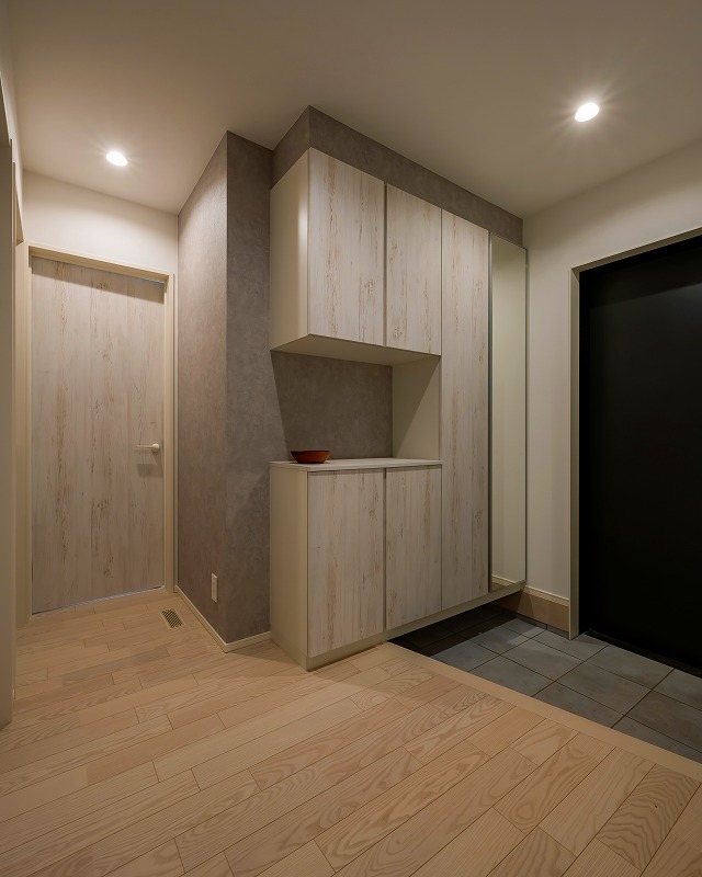 木目調のシューズボックスと扉がやさしい雰囲気の玄関。
壁面の一部をくぼませたニッチは、小物や季節の飾りを置くスペースとして活躍します。
全身を映せるミラーも備え、外出前の身だしなみチェックにも便利です。