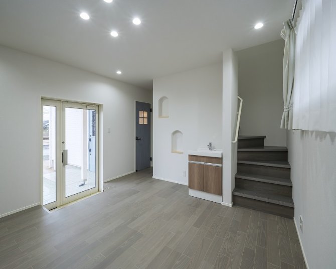 店舗塀用住宅ならではの動線設計。
階段横の手洗いとニッチが実用性とデザイン性を兼ね備えた心地よい空間を演出します。