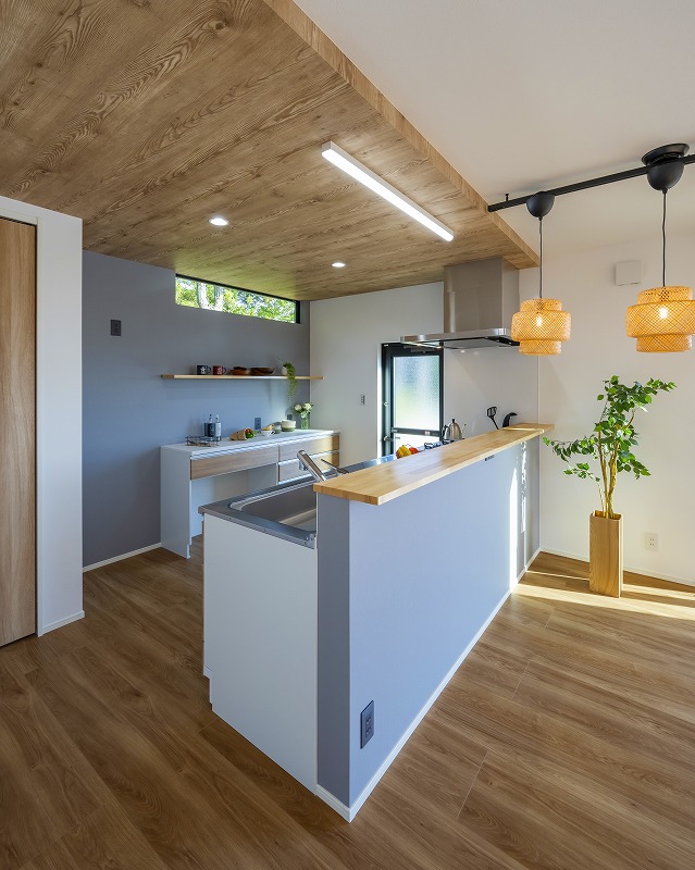 木目調の下がり天井とフローリングが、温もりある空間に。
ブルーのアクセントクロスとカフェ風の照明が洗練されたキッチン空間を引き立てます。