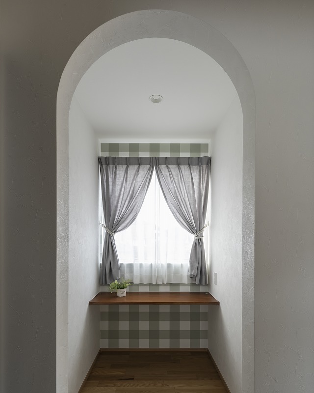 チェック柄クロスがアクセントの小さな書斎コーナー。
やわらかな光が差し込む、心落ち着く空間です。