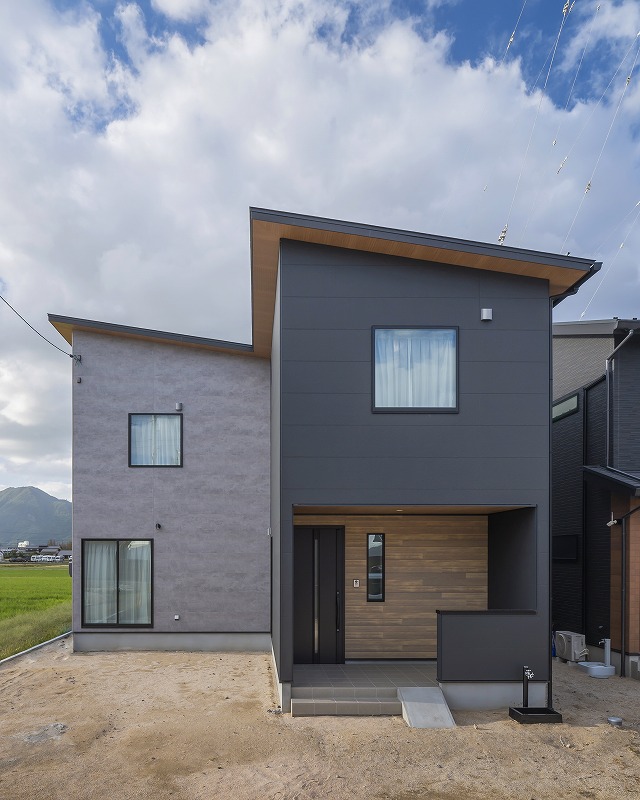 KMEWの外壁を採用したツートンカラーに、木目のアクセントが温もりをプラス。
片流れを組み合わせ立体的な外観がシンプルながらも印象的な佇まいを演出します。
