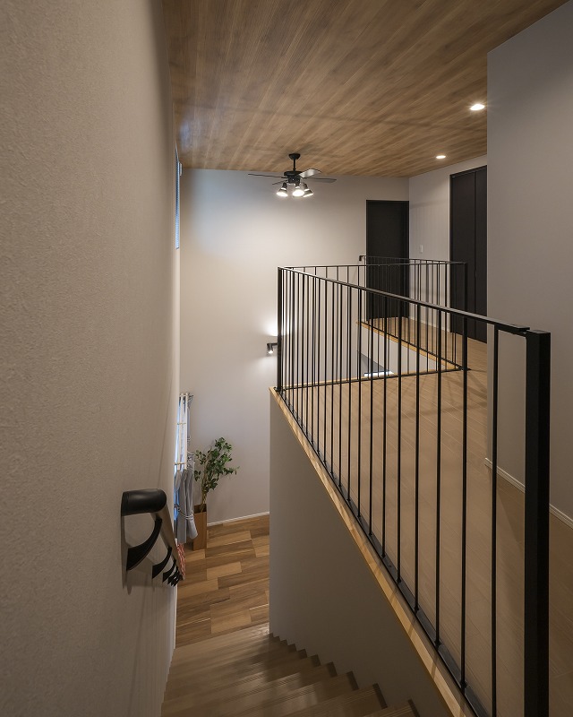 吹き抜けとアイアン手すりが魅せる開放感抜群の階段ホール。
黒のアイアン手すりと建具が空間を引き締めます。