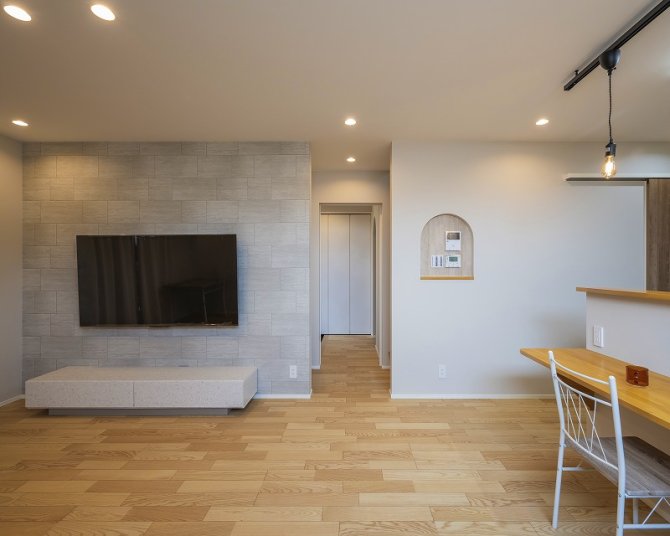 グレーの石目調タイルをあしらった壁が存在感を放ち、上質で落ち着いた雰囲気のリビング。
壁掛けテレビとローボードを組み合わせることで、空間をすっきりと見せながら、ホテルライクな洗練さを実現します。