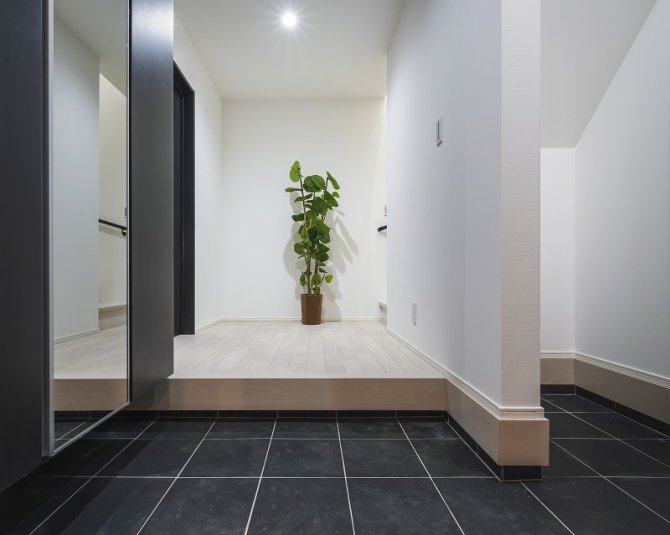 ブラックのタイルが空間を引き締める玄関は、シンプルでありながら洗練された印象を与えます。大きなシューズ収納に加え、階段下収納も確保しているので、靴や日用品までスッキリ収まります♪