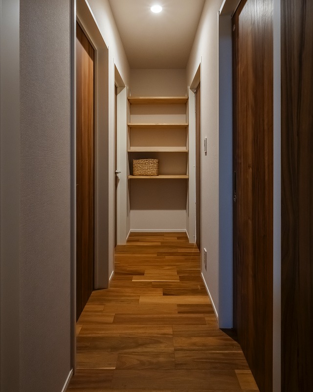 廊下の突き当たりに設けたオープン収納は、動線上で使いやすい計画。造作棚が空間になじみ、使いやすさとすっきりとした見た目を両立しています。