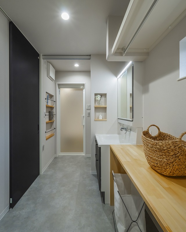 造作カウンターは洗濯物を畳んだり作業がしやすように設計。カウンター下にはタンスが収まるように高さを計画。浴室から届く位置にはタオルニッチを採用。タオルをくるくると巻いて「立てる収納」で見た目もスッキリします。