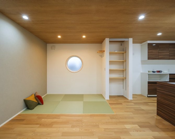 リビングに設けた約3帖のフラット畳コーナーは、キッズスペースとして大活躍。キッチンから見守れるので、家事と子育てを両立できます。壁面に設けた丸窓がやさしい光を取り込みます。